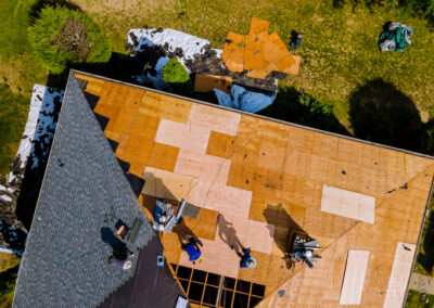 Roof construction repairman on a residential apartment with new roof shingle being applied