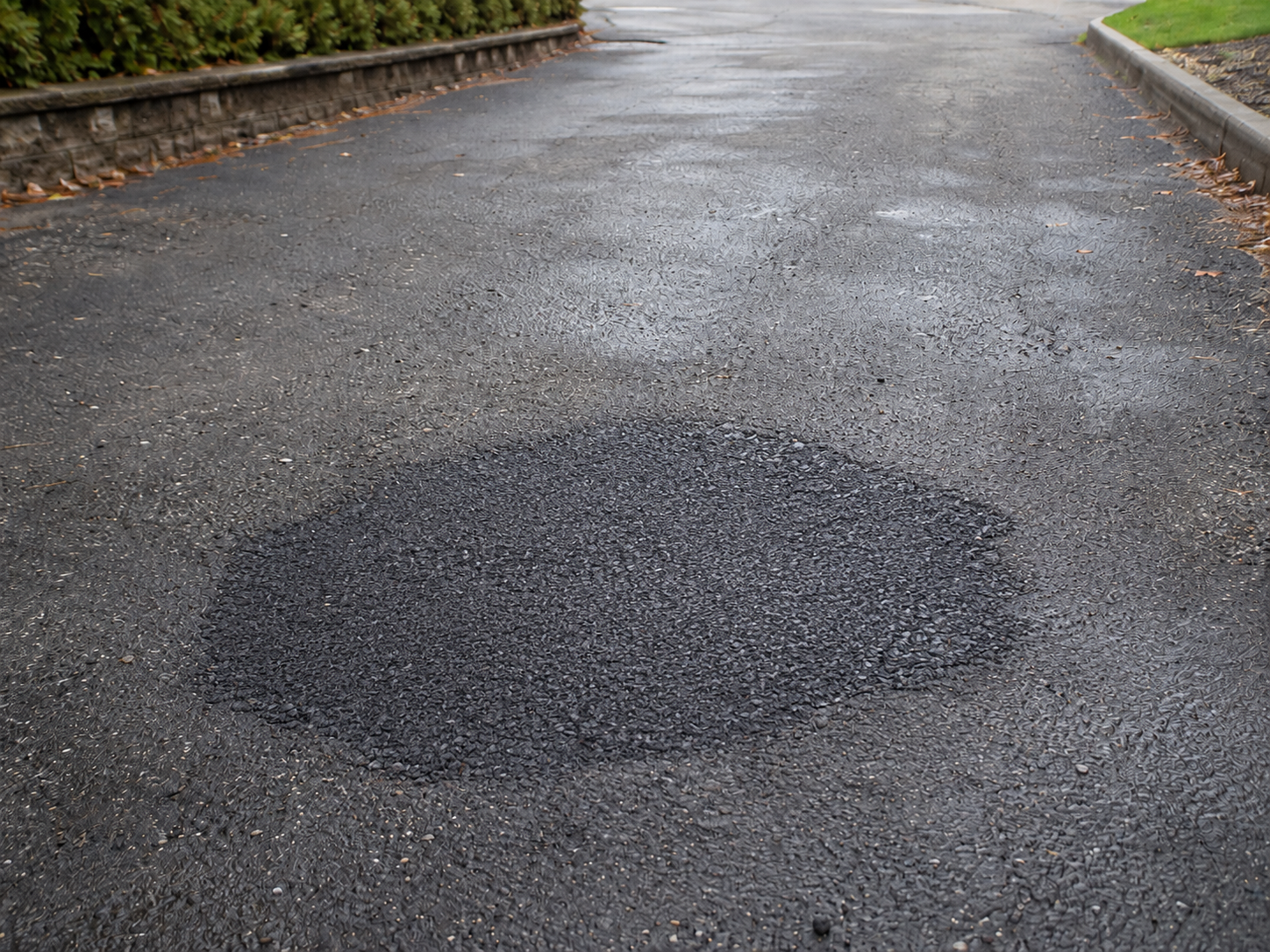 Asphalt repair before and after transformation showing a repaired pothole on a private road