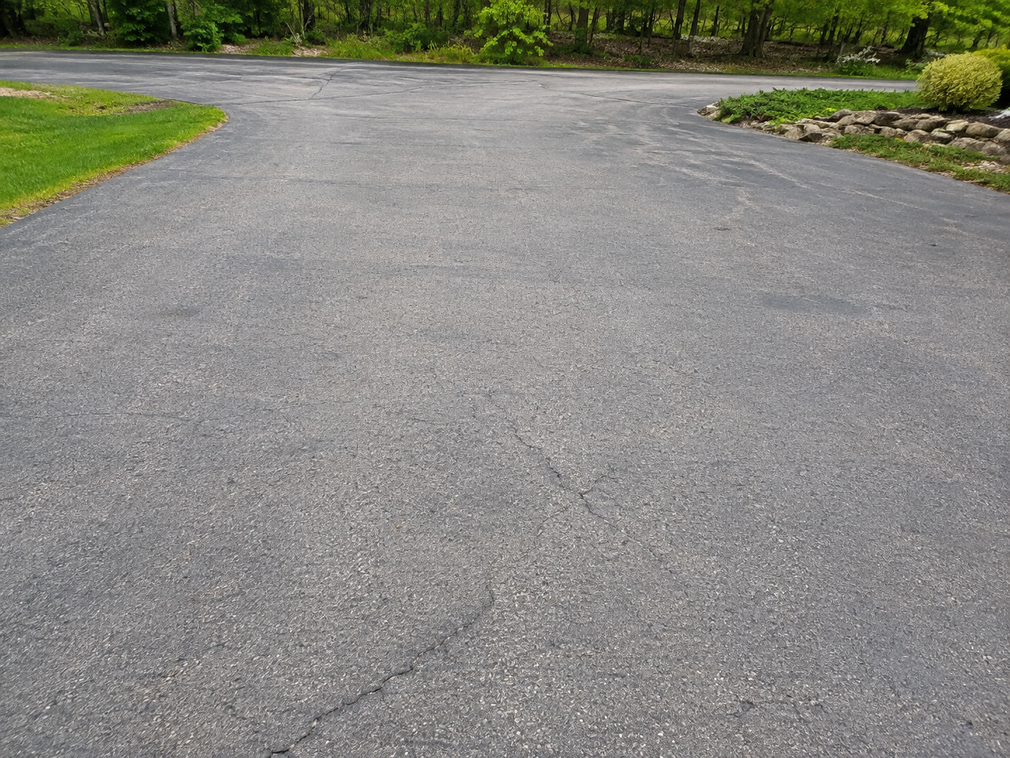 Asphalt sealcoating before and after example showing faded pavement before service