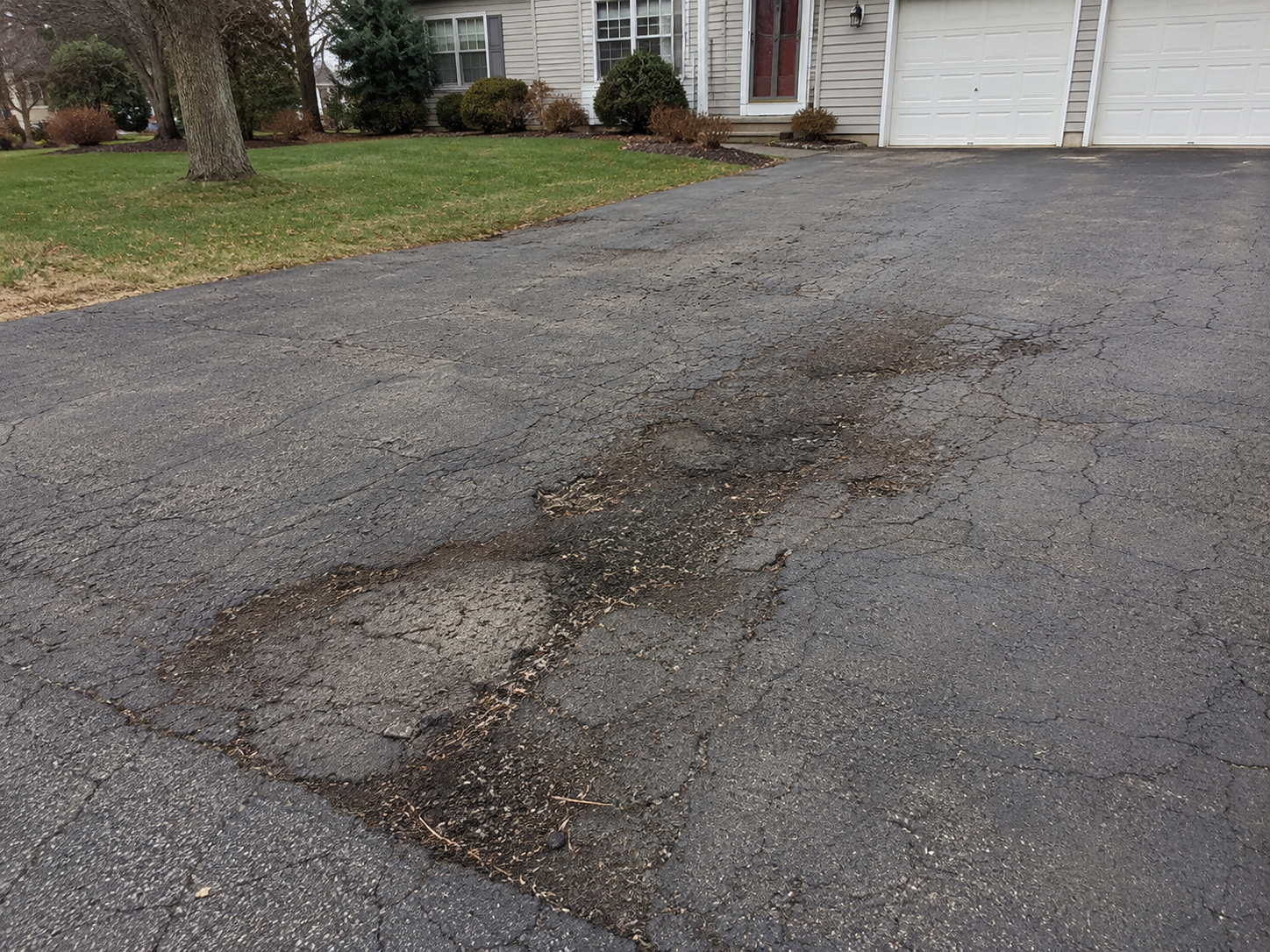 Asphalt driveway repair before and after example showing driveway damage before professional repair