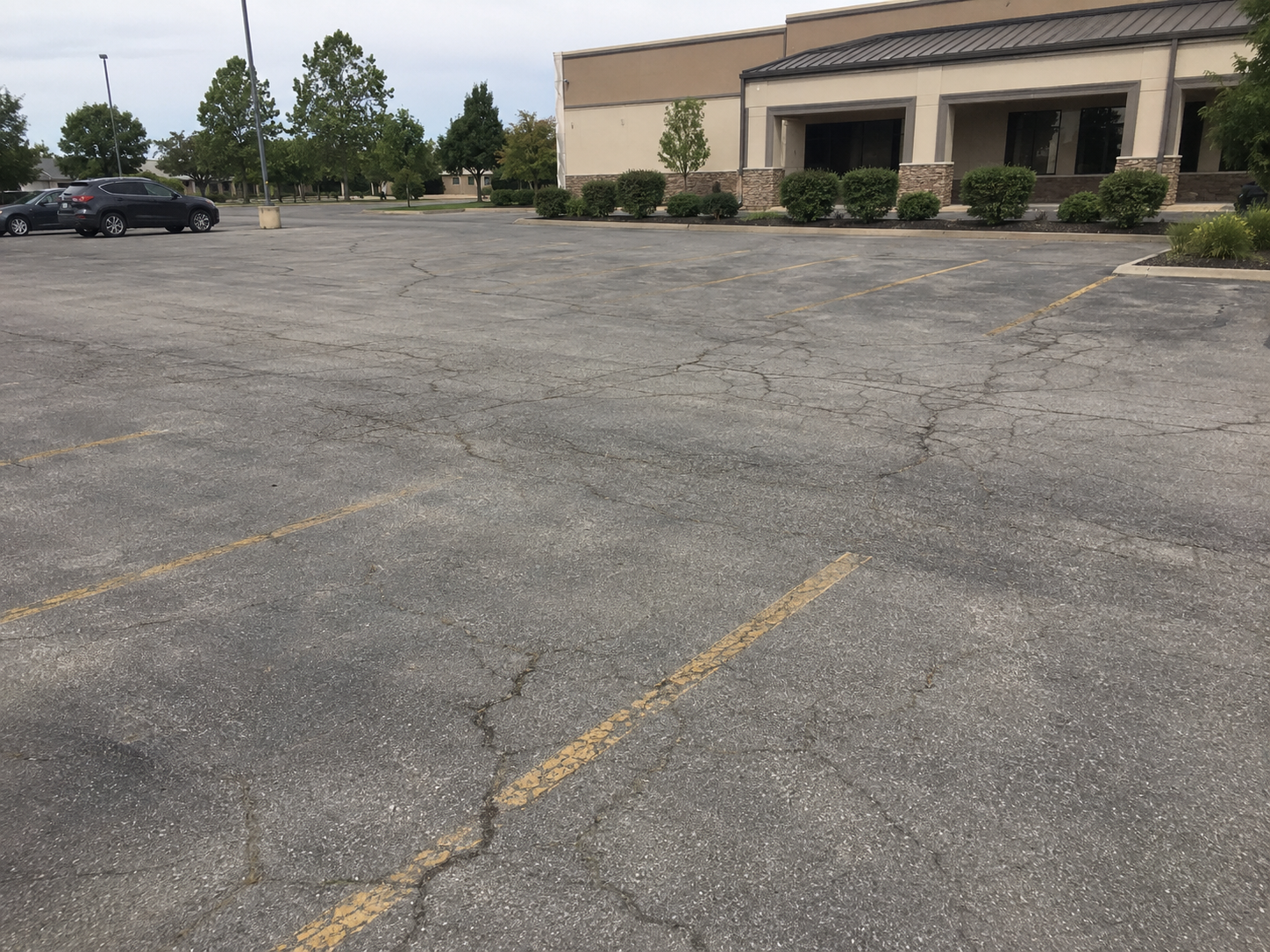 Commercial asphalt repair before and after example showing parking lot cracks before maintenance